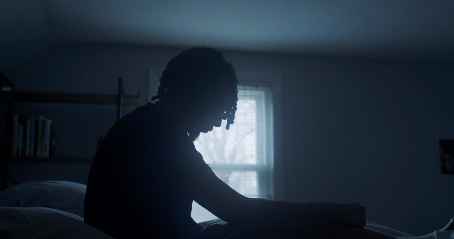 Nicolas Andrew sitting up his bed and looking down in Alone | Nicolas Andrew Visuals