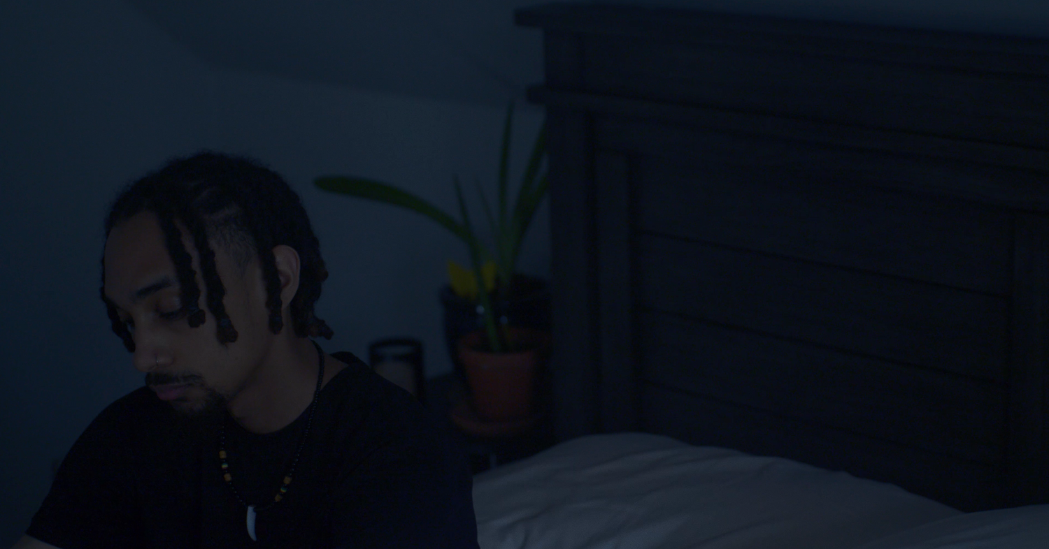 Nicolas Andrew sitting up and looking down on bed in Alone | Nicolas Andrew Visuals